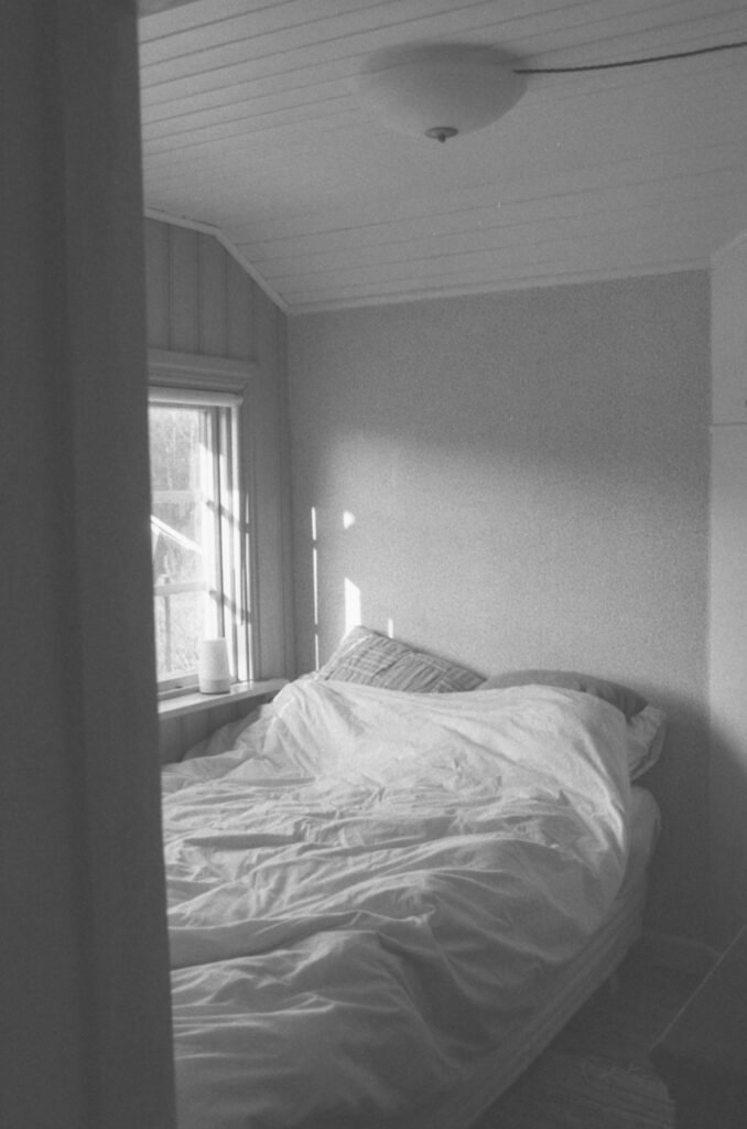 Dormitorio con cama hecha y luz de ventana (foto ilustrativa)