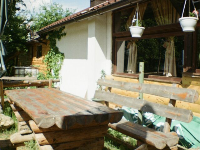 Mesa rústica de madera en el jardín (foto ilustrativa)
